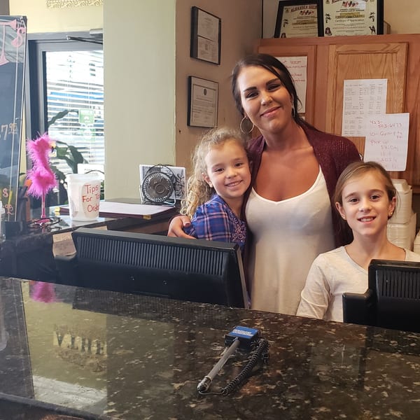 A woman and two young girls smile behind the counter at Portofino's Italian Restaurant.