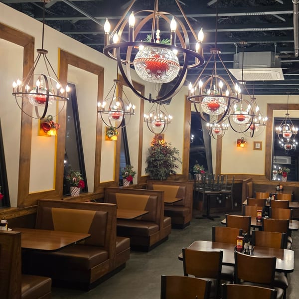 Portofino's dining room with booths, tables, and ornate chandeliers decorated for Christmas.
